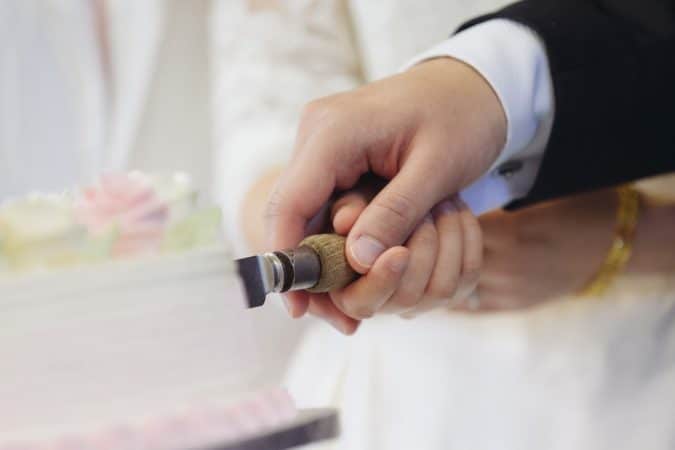 man and woman slicing cake