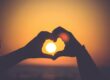 silhouette of person's hands forming heart