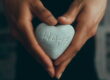 person holding gray heart shape ornament